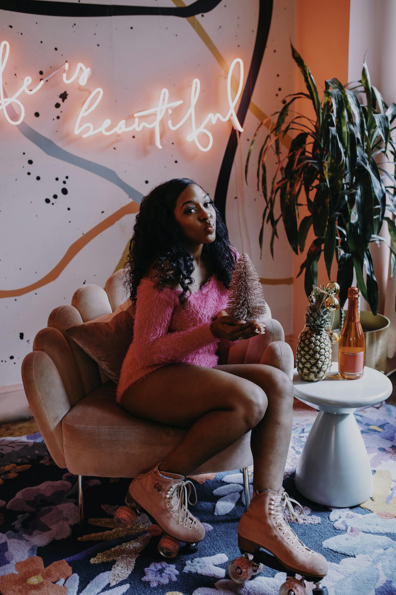 Young woman in roller skates sits in a colorful room with neon lights, creating a trendy atmosphere.